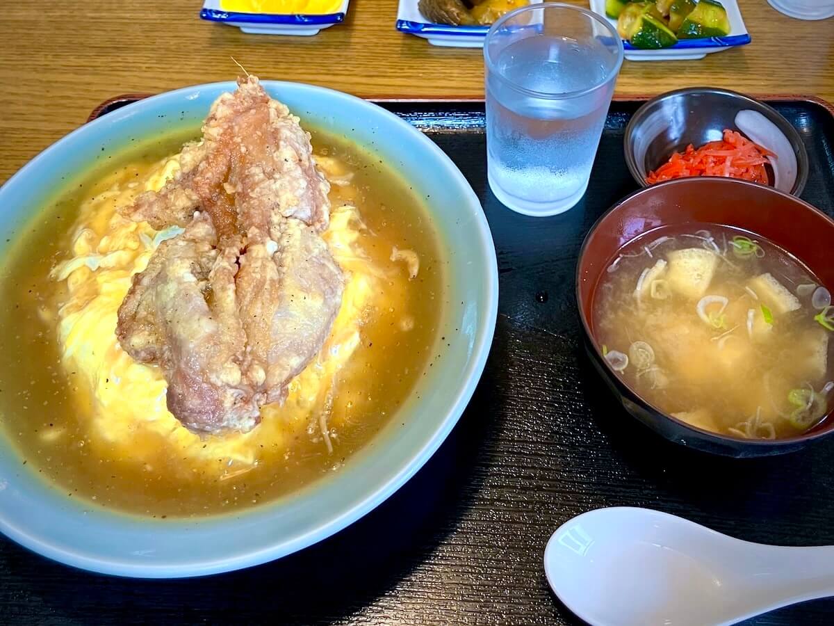 テーブルに運ばれてきたデカ唐揚天津飯とお味噌汁のセット
